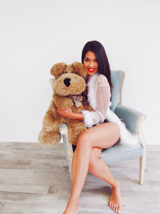 a woman sitting on a chair holding a teddy bear 